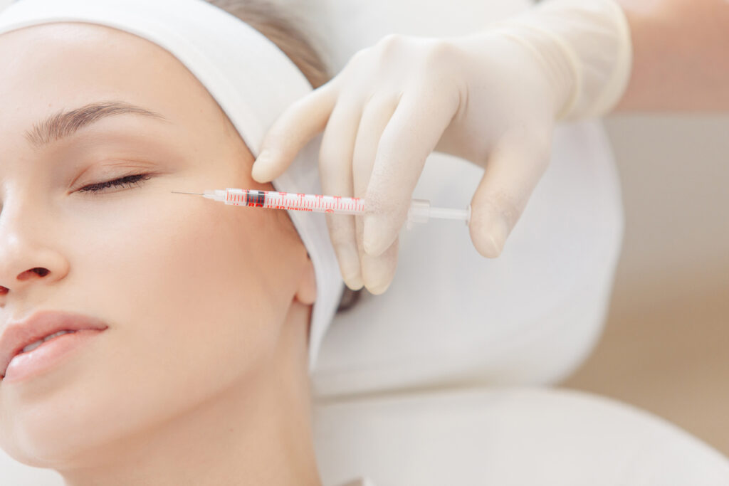 Cosmetologist doing a syringe beauty shots.
